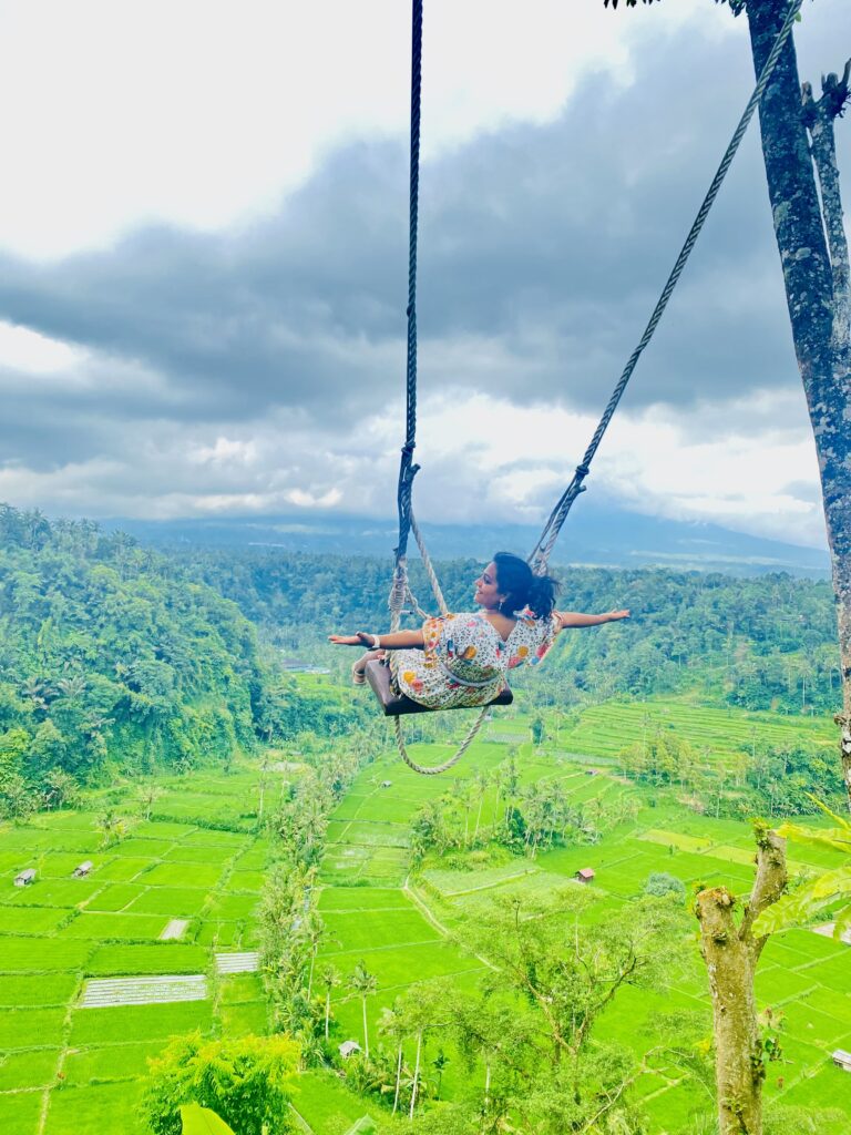 A girl on Bali Swing overlooking Rice terraces